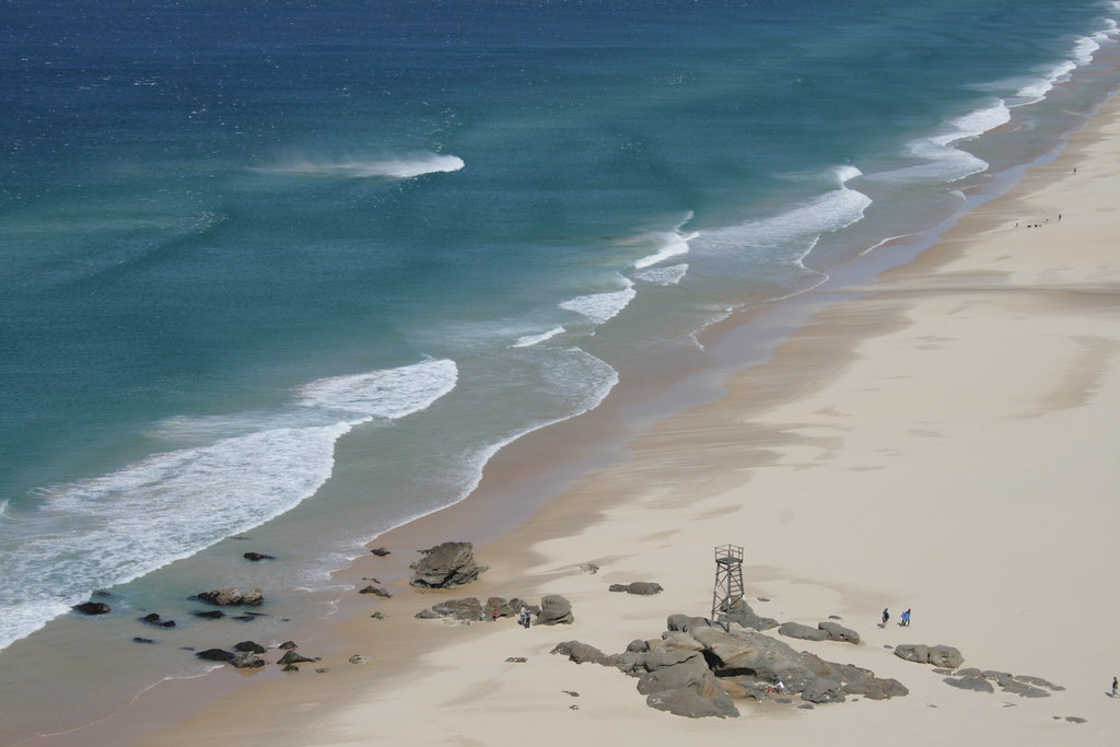 Redhead Beach — a long sweep of sand and surf, with the timber Shark Tower on the rocks at the south end