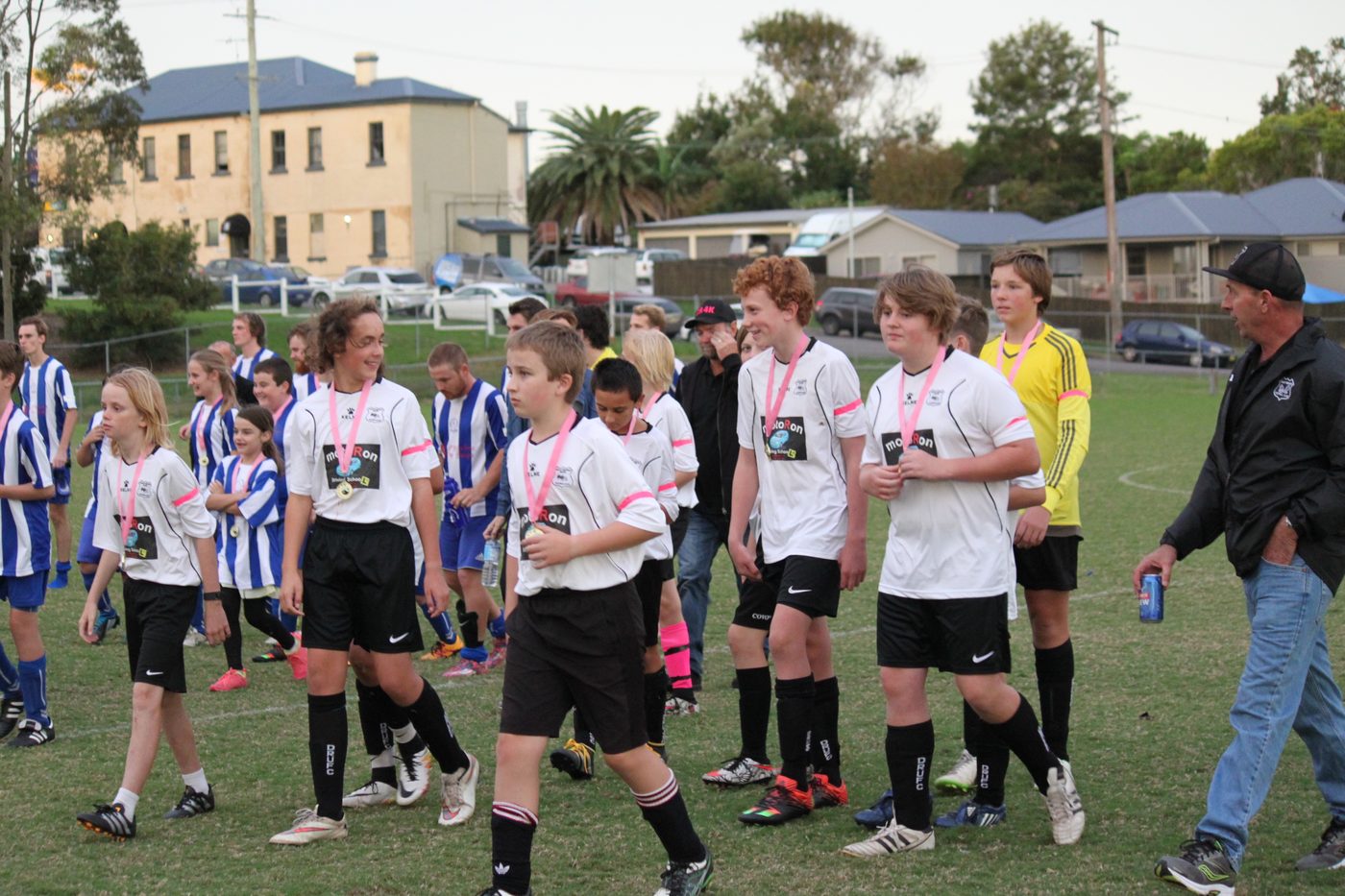 A DRUFC junior team celebrating with medals after a presentation
